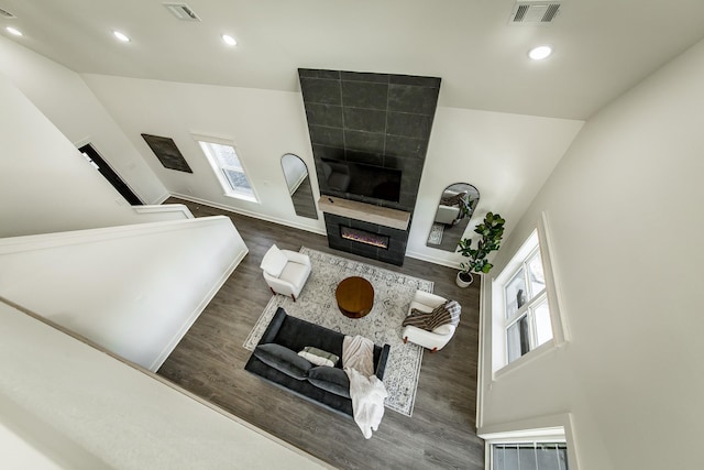 living room with dark wood-type flooring, a fireplace, and a wealth of natural light