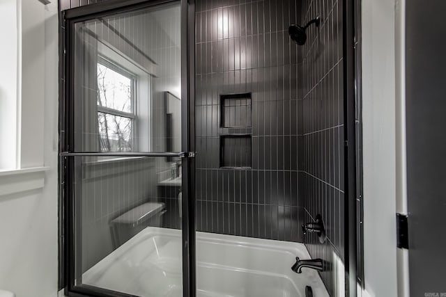 bathroom featuring combined bath / shower with glass door