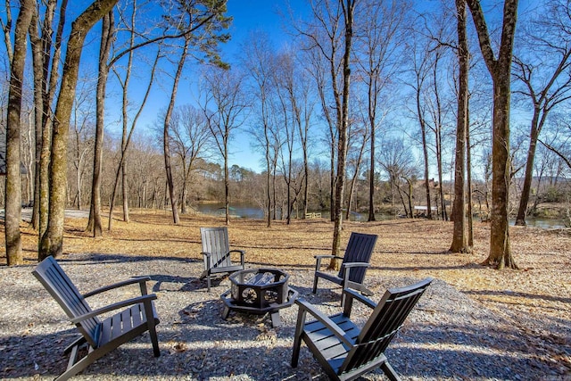 view of yard with a water view and an outdoor fire pit