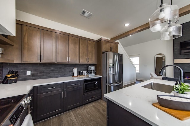 kitchen with dark brown cabinetry, sink, decorative light fixtures, and appliances with stainless steel finishes