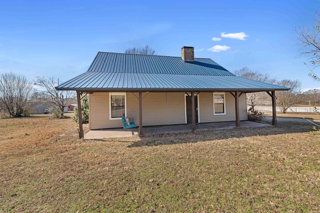 back of property with a patio and a yard