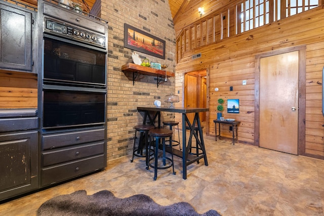 kitchen with high vaulted ceiling and wooden walls