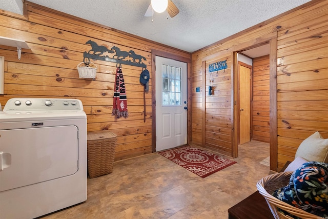 washroom with ceiling fan, washer / dryer, a textured ceiling, and wood walls