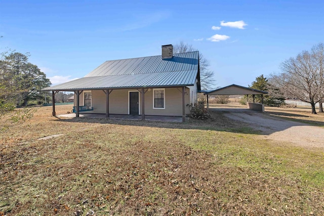 rear view of property featuring a porch and a yard