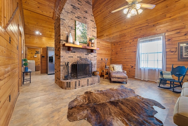 living room featuring wooden walls, washer / clothes dryer, and high vaulted ceiling