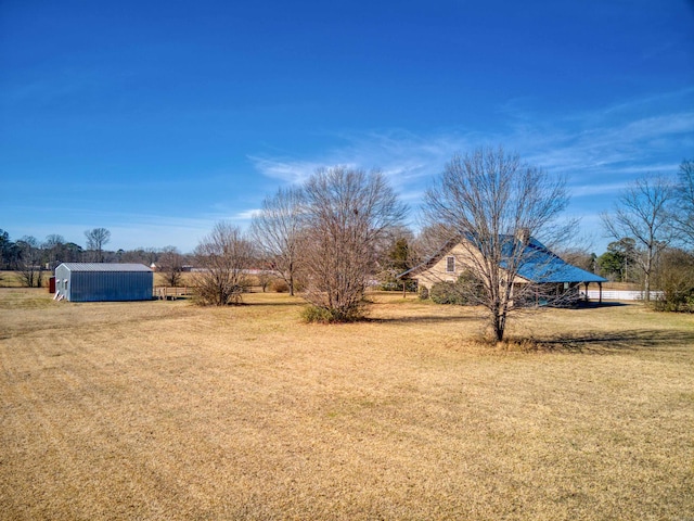 view of yard with a shed and a rural view