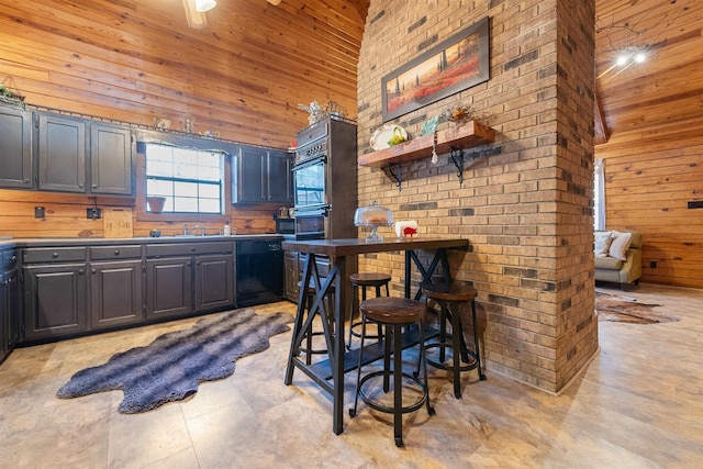 kitchen featuring sink, wooden walls, black dishwasher, a high ceiling, and wall oven