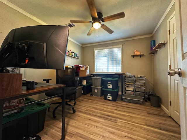 home office with crown molding, ceiling fan, and light hardwood / wood-style floors