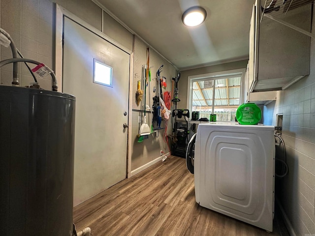 clothes washing area with wood-type flooring, hookup for a washing machine, and water heater