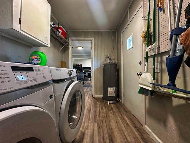 laundry room featuring cabinets, hardwood / wood-style flooring, independent washer and dryer, and water heater