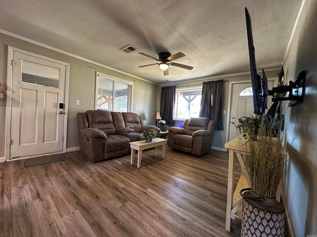 living room with hardwood / wood-style flooring, ornamental molding, a textured ceiling, and ceiling fan