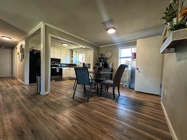 dining space featuring ornamental molding and dark hardwood / wood-style flooring