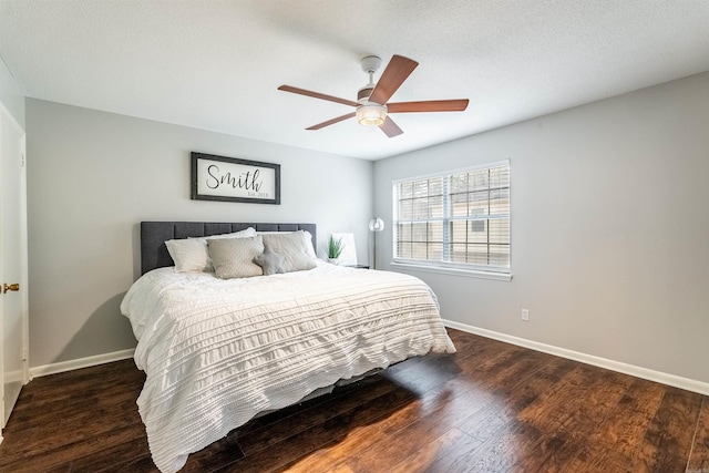 bedroom featuring dark hardwood / wood-style flooring, a textured ceiling, and ceiling fan