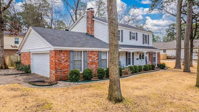 front facade with a garage, a front yard, and covered porch