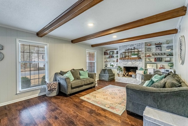 living room with dark wood-type flooring, built in features, a fireplace, a textured ceiling, and beamed ceiling