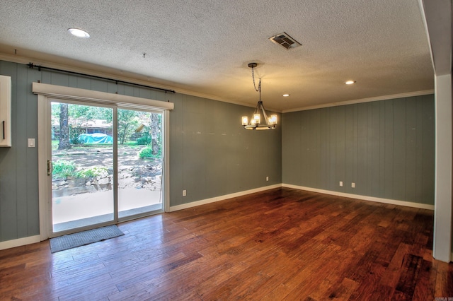 spare room featuring crown molding, a textured ceiling, wood-type flooring, and a notable chandelier