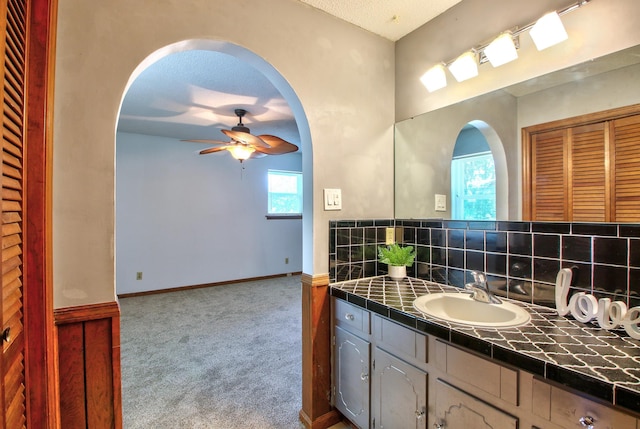 bathroom featuring a textured ceiling, ceiling fan, backsplash, and vanity