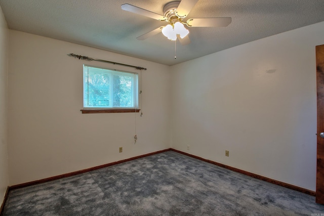 empty room with dark carpet, ceiling fan, and a textured ceiling