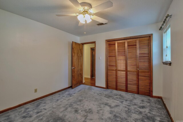 unfurnished bedroom with ceiling fan, carpet floors, a textured ceiling, and a closet