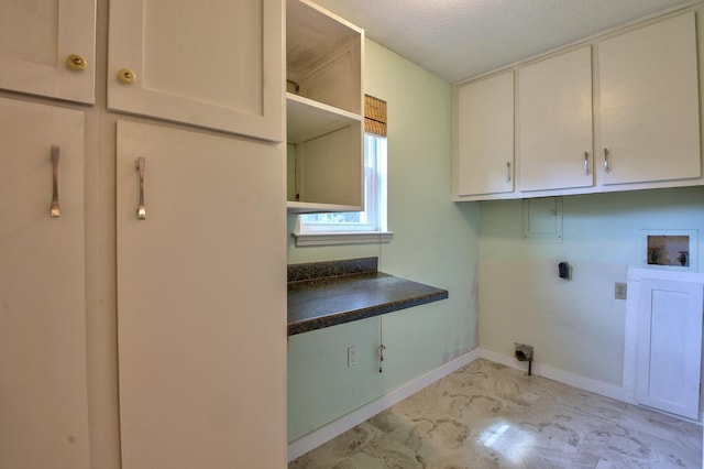 washroom with a textured ceiling, cabinets, washer hookup, and electric dryer hookup