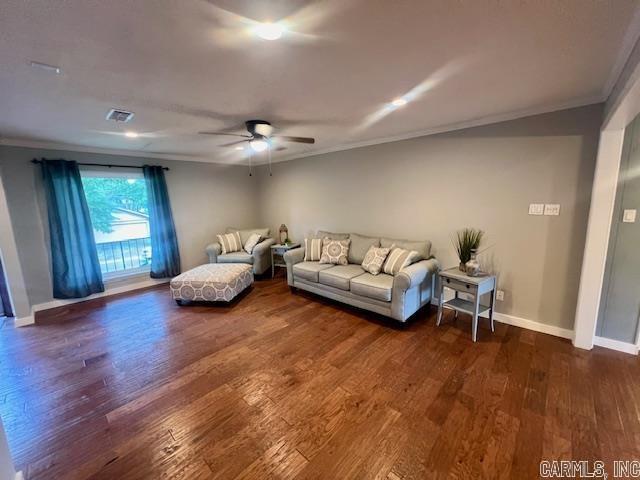 living room with ornamental molding, dark hardwood / wood-style floors, and ceiling fan