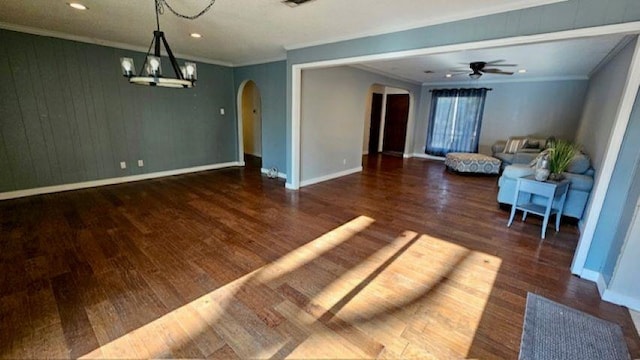 unfurnished living room featuring ornamental molding, dark hardwood / wood-style floors, and ceiling fan with notable chandelier