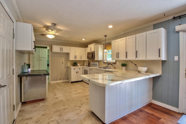 kitchen featuring sink, white range with electric stovetop, pendant lighting, white cabinetry, and kitchen peninsula