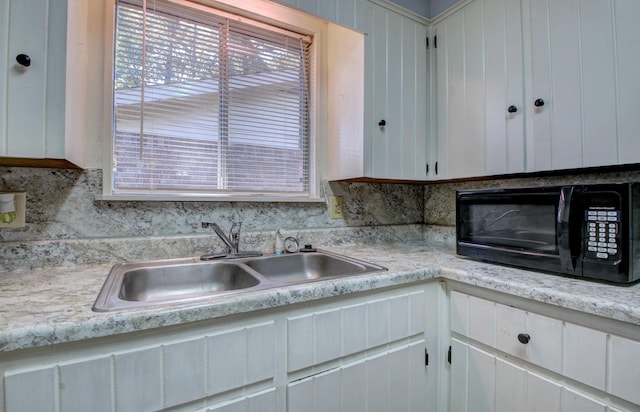 kitchen with white cabinetry, sink, and backsplash