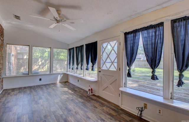 interior space featuring dark wood-type flooring, a wealth of natural light, and a textured ceiling