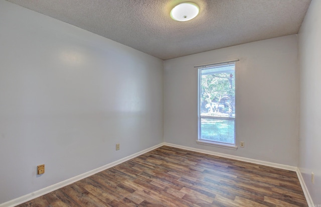 unfurnished room with dark hardwood / wood-style floors and a textured ceiling