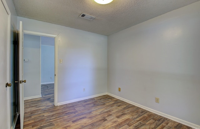 unfurnished room with dark hardwood / wood-style floors and a textured ceiling