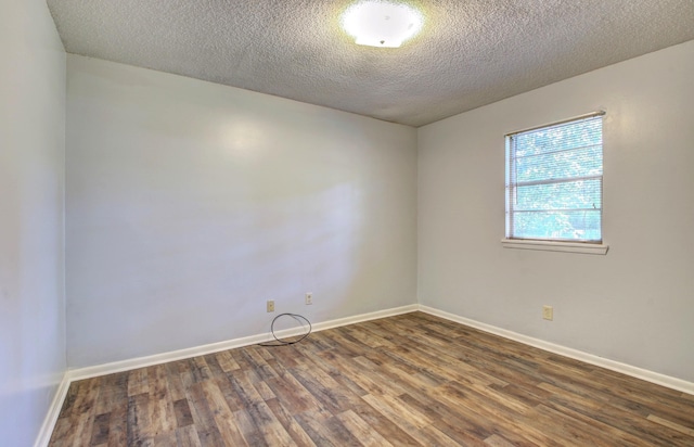 unfurnished room featuring dark wood-type flooring and a textured ceiling