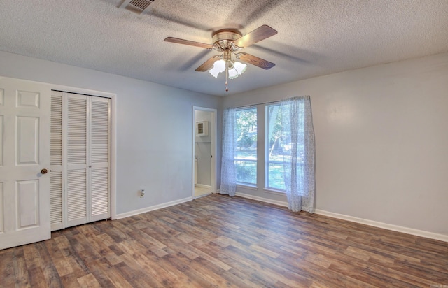 unfurnished bedroom with a closet, dark hardwood / wood-style floors, a textured ceiling, and ceiling fan