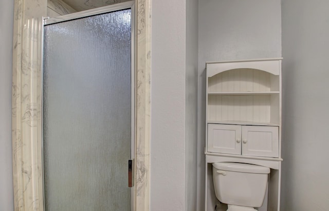 bathroom with toilet and a shower with shower door