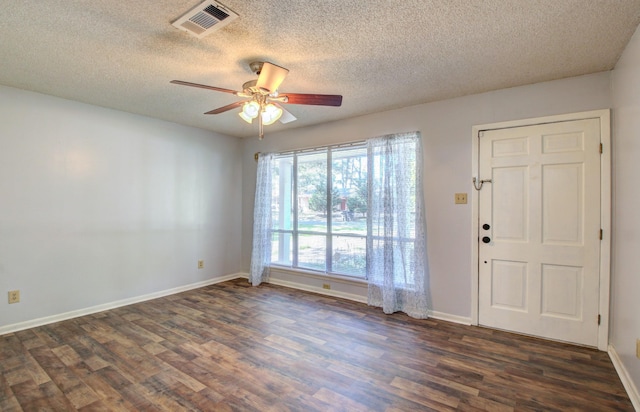 spare room with ceiling fan, dark hardwood / wood-style flooring, and a textured ceiling