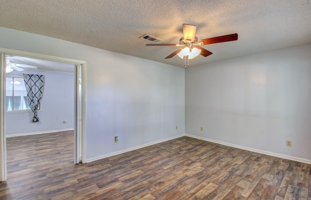 spare room with ceiling fan, dark wood-type flooring, and a textured ceiling