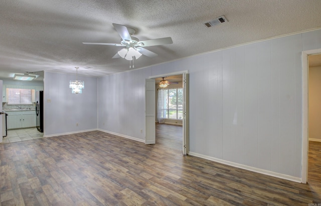 unfurnished room with ceiling fan with notable chandelier, hardwood / wood-style floors, and a textured ceiling