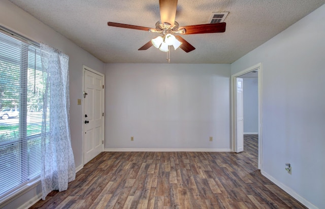 unfurnished room featuring ceiling fan, dark hardwood / wood-style floors, and a textured ceiling