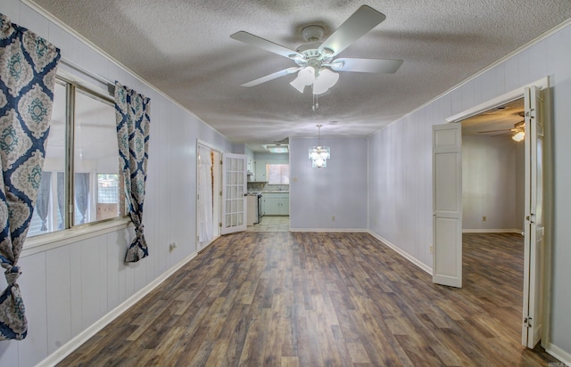 spare room with ornamental molding, dark hardwood / wood-style floors, ceiling fan with notable chandelier, and a textured ceiling