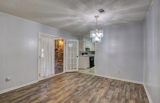 interior space with a textured ceiling, ornamental molding, light hardwood / wood-style floors, and a chandelier