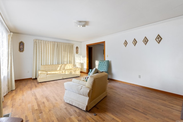 living room featuring ornamental molding and light wood-type flooring