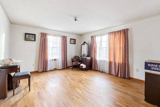 living area with ornamental molding and light hardwood / wood-style floors