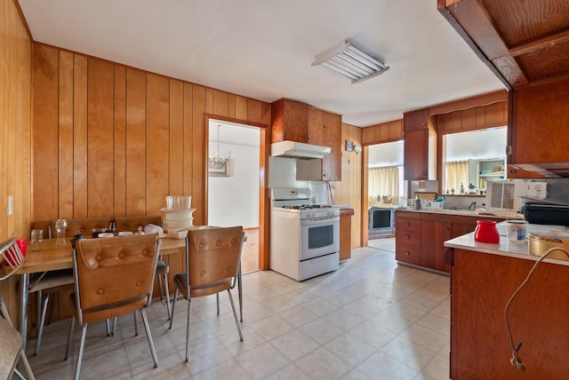 kitchen with gas range gas stove and wood walls