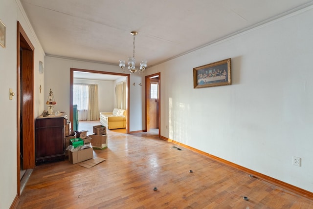 dining space with ornamental molding, hardwood / wood-style floors, and an inviting chandelier