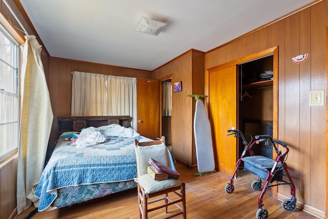 bedroom featuring wooden walls and light hardwood / wood-style floors