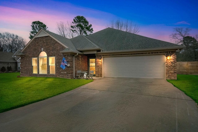 ranch-style house featuring a garage and a yard