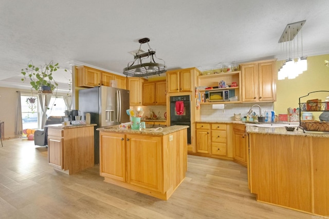 kitchen with appliances with stainless steel finishes, decorative backsplash, a kitchen island, decorative light fixtures, and light wood-type flooring