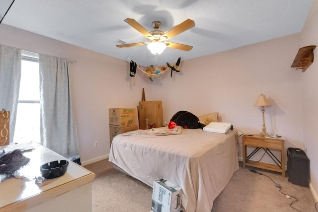 bedroom with light carpet, multiple windows, and ceiling fan