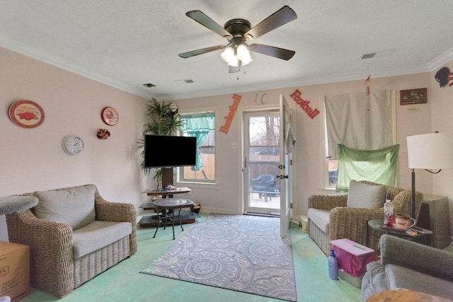 carpeted living room featuring crown molding and ceiling fan