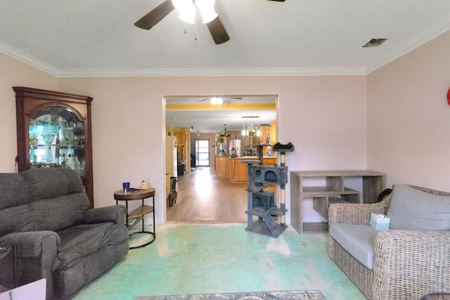 living room with ornamental molding, ceiling fan, and light hardwood / wood-style flooring